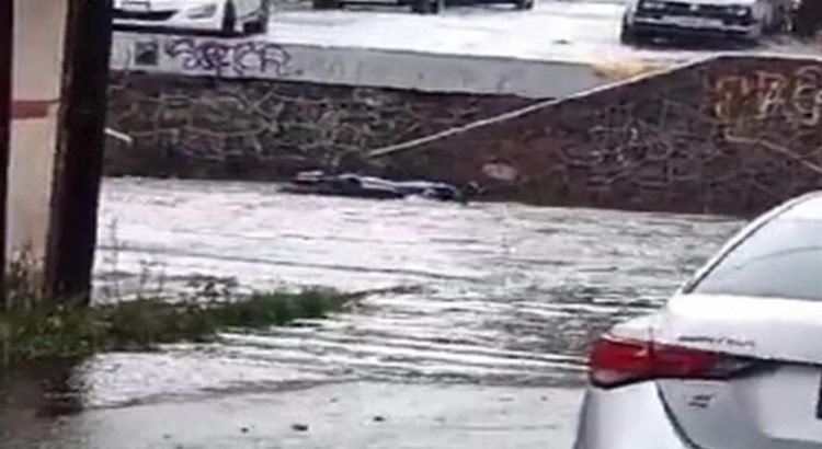Lluvias arrastran moto tras lluvias torrenciales en Toluca
